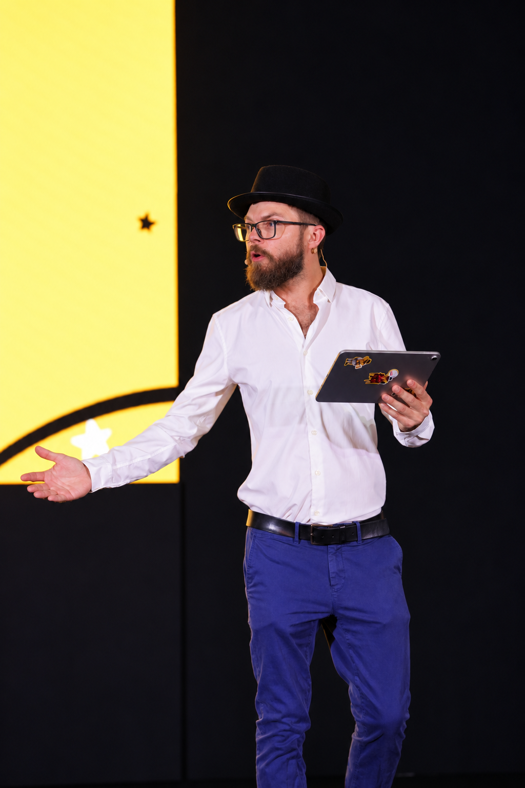 Tony Jacobs on stage with a microphone and tablet
